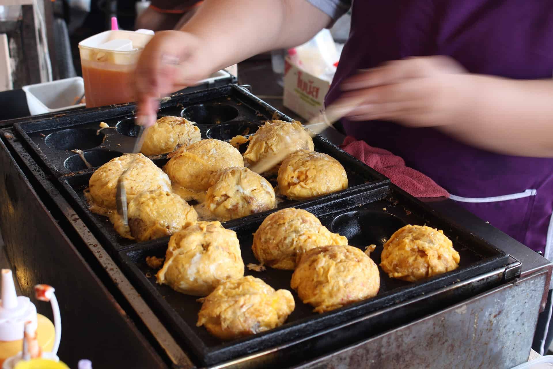 alguém está fazendo takoyaki com panela de takoyaki