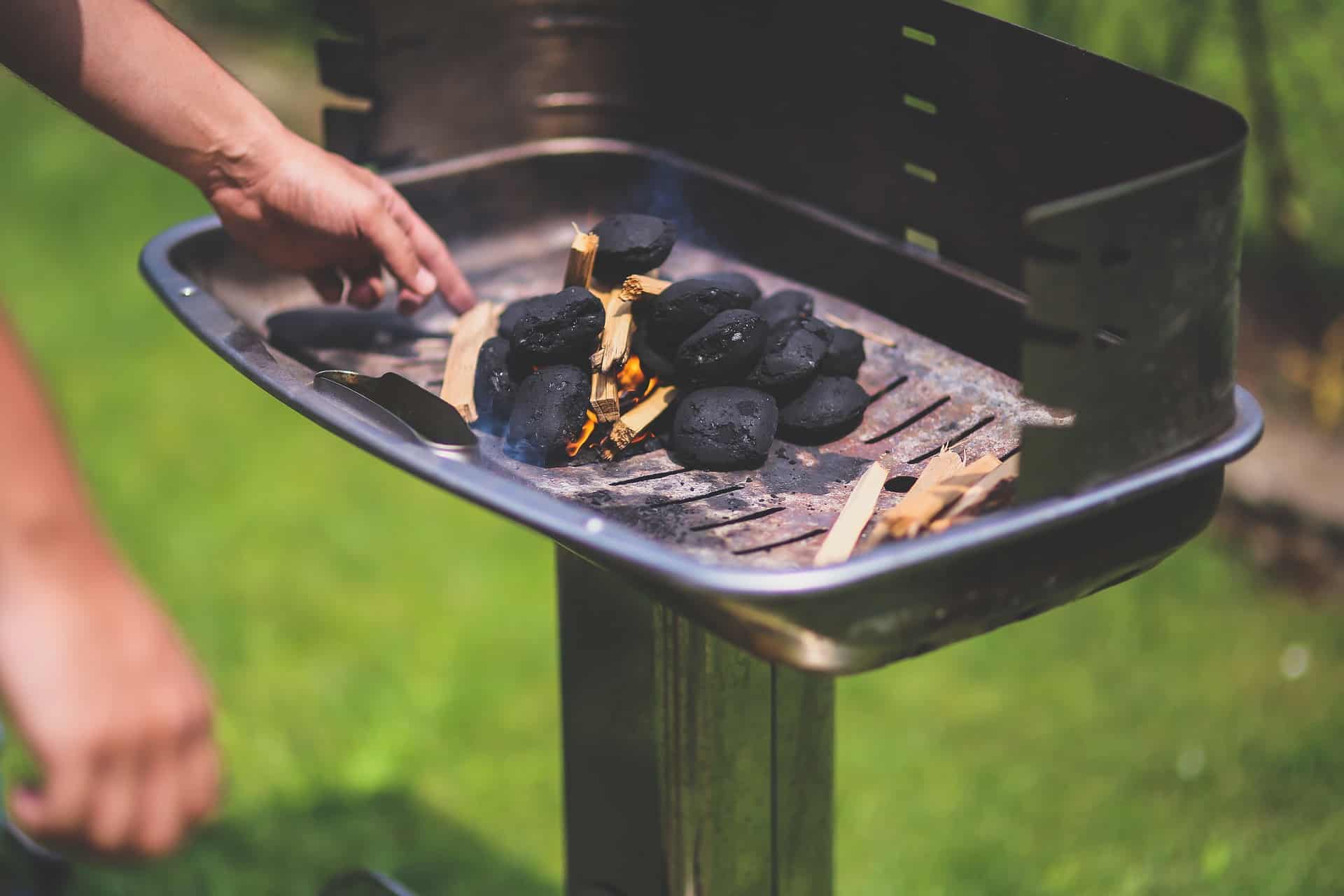 någon eldar upp grillen med briketter