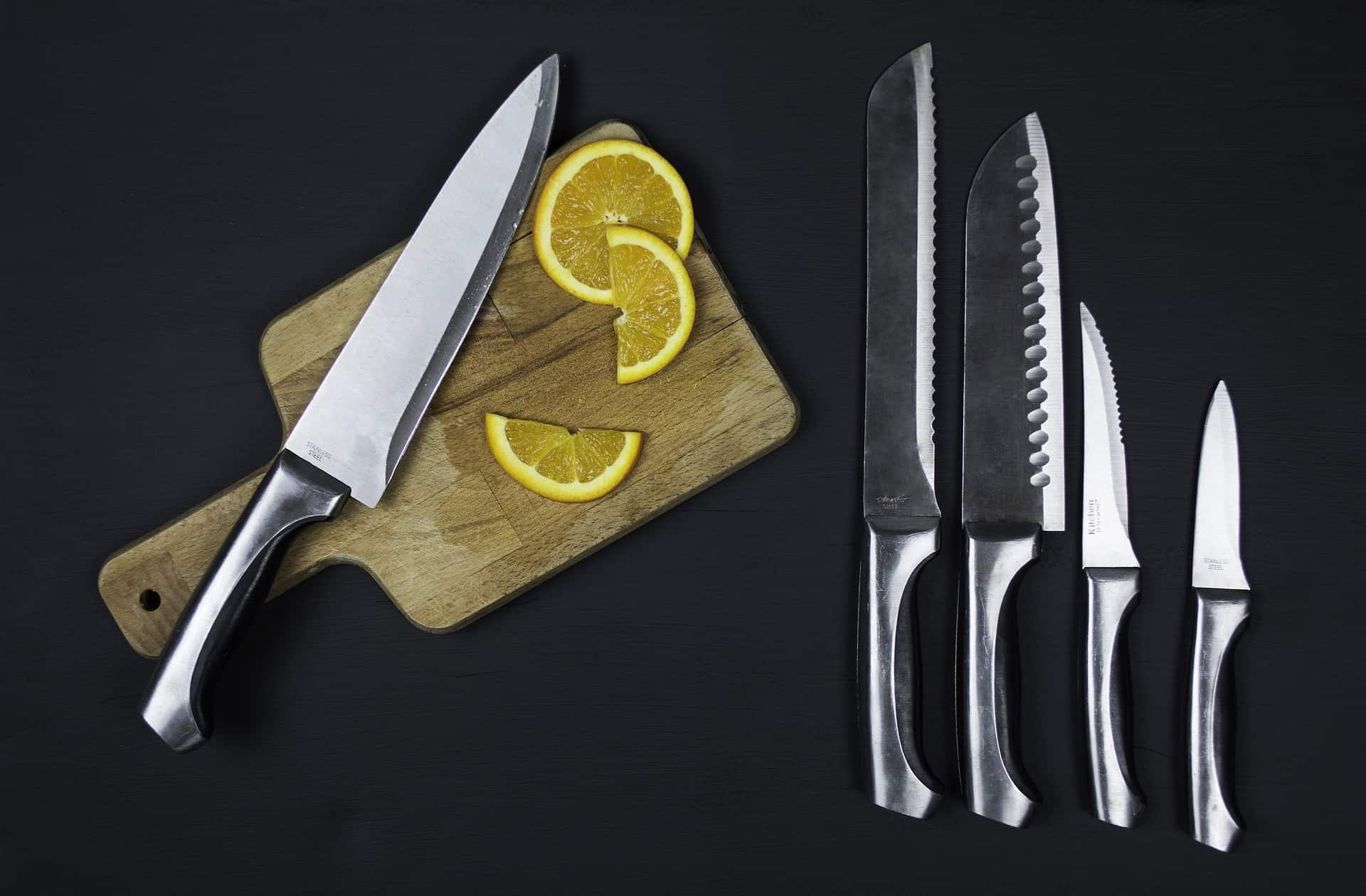 a cutting board with slice of lemons and knives set