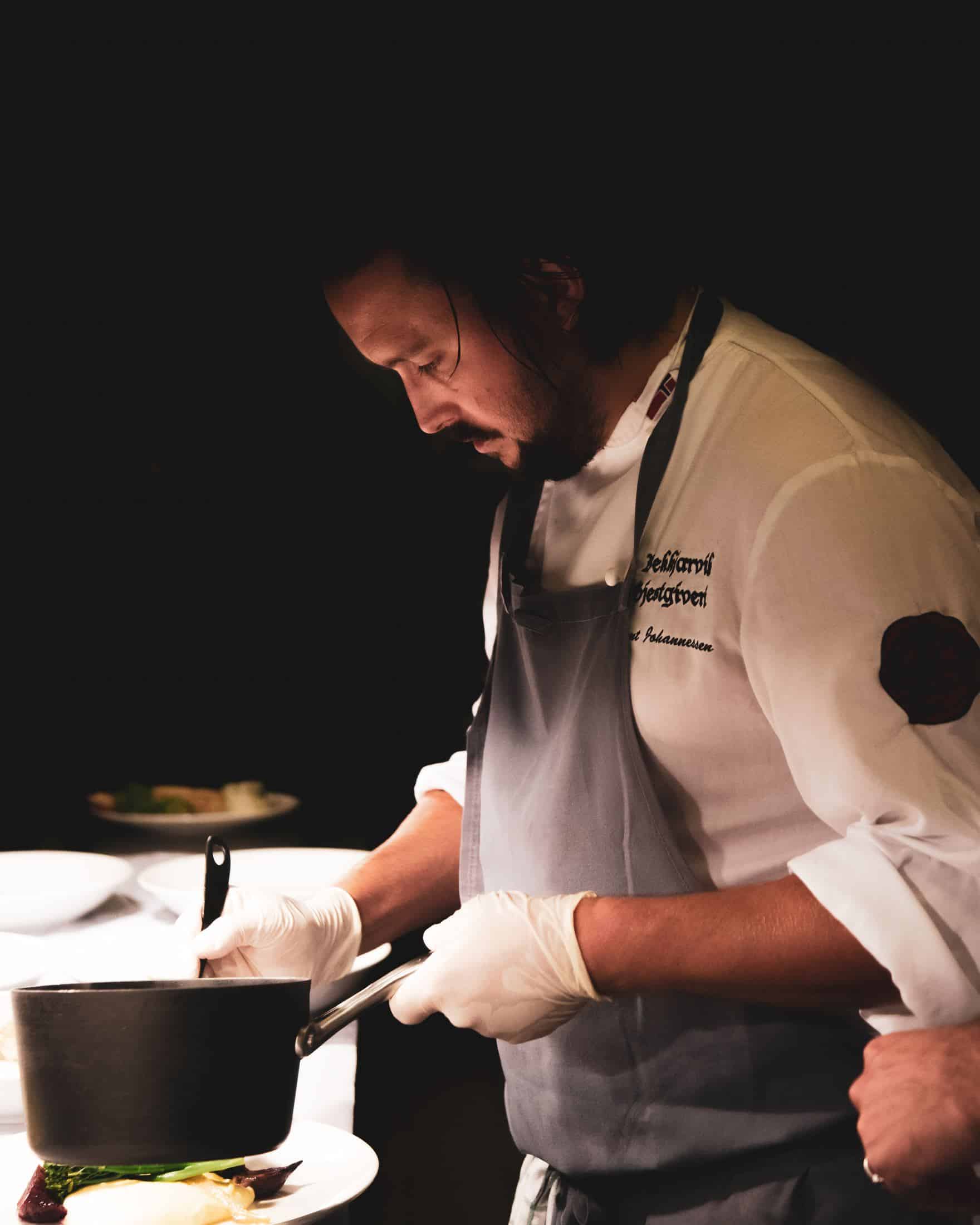 um chef está mexendo algo dentro da panela