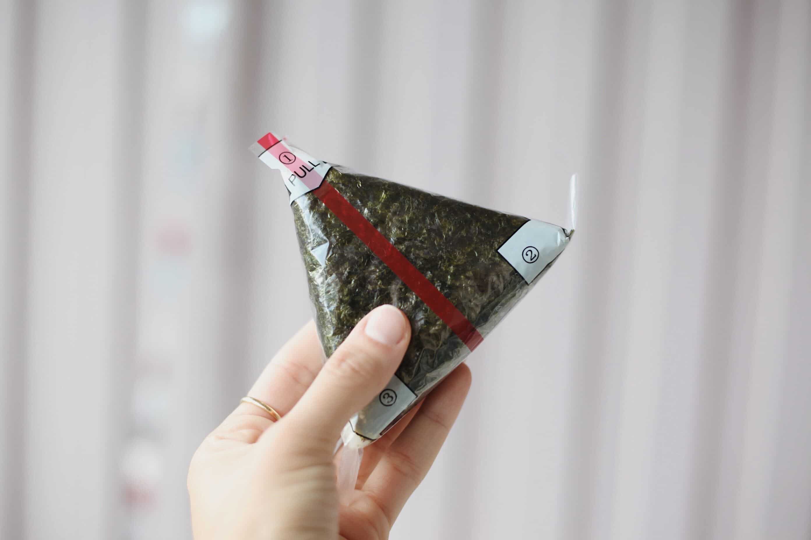 uma pessoa segurando um onigiri