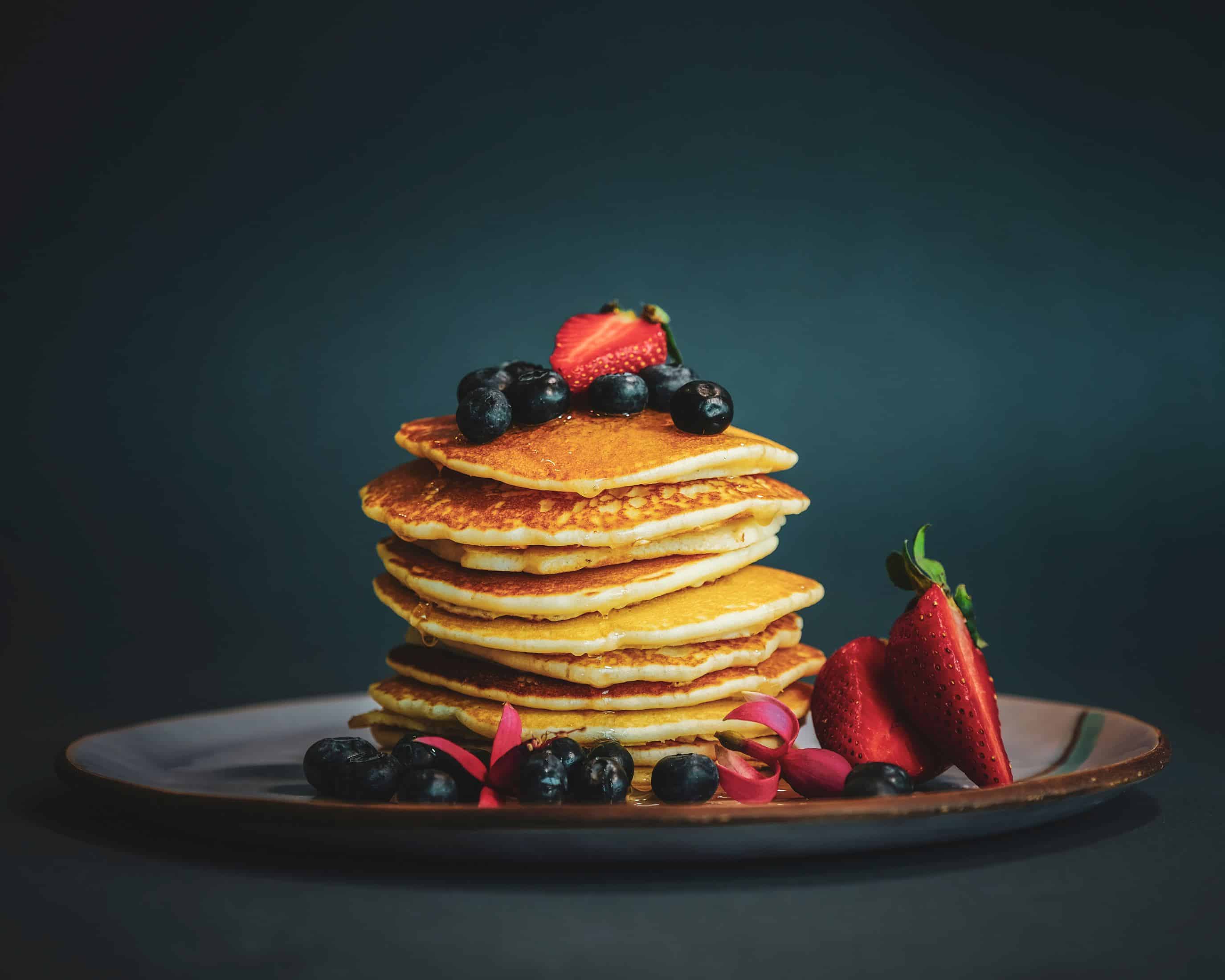 en tallrik med pannkakor med blåbär och jordgubbar