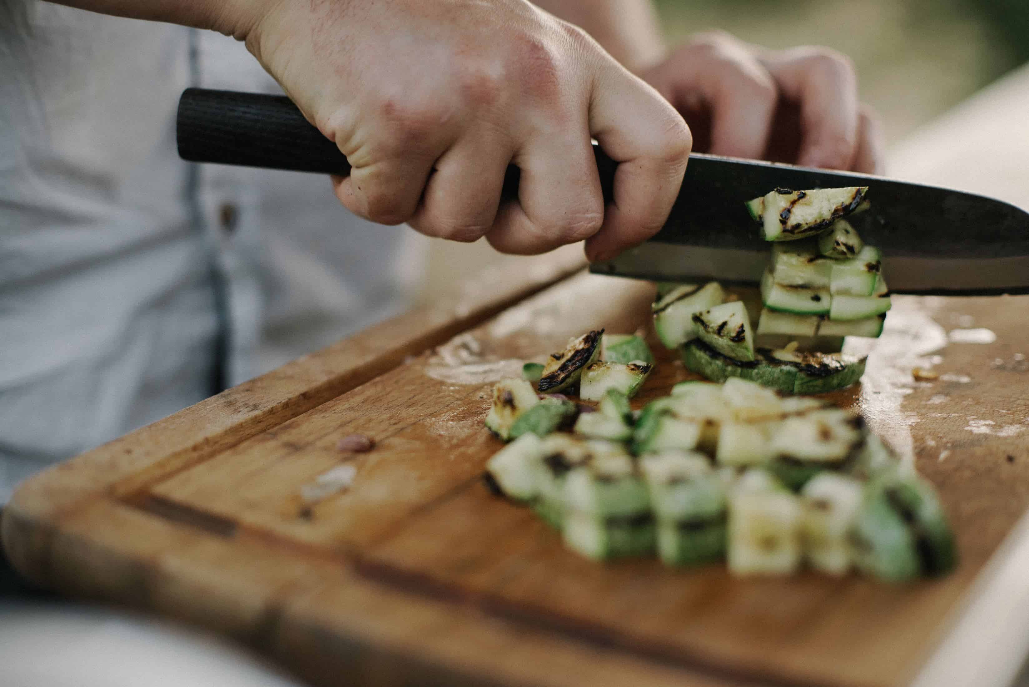 persoa picar verduras cun coitelo