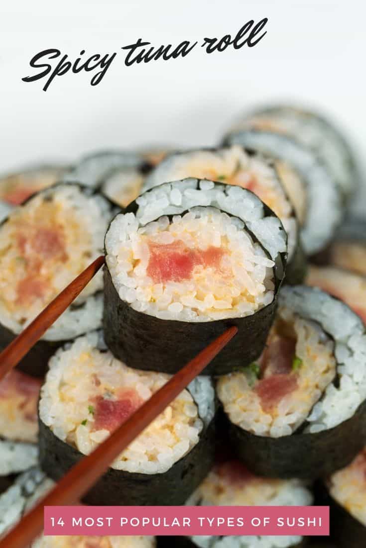Bacchette che raccolgono il pezzo di tonno piccante superiore per una pila di sushi