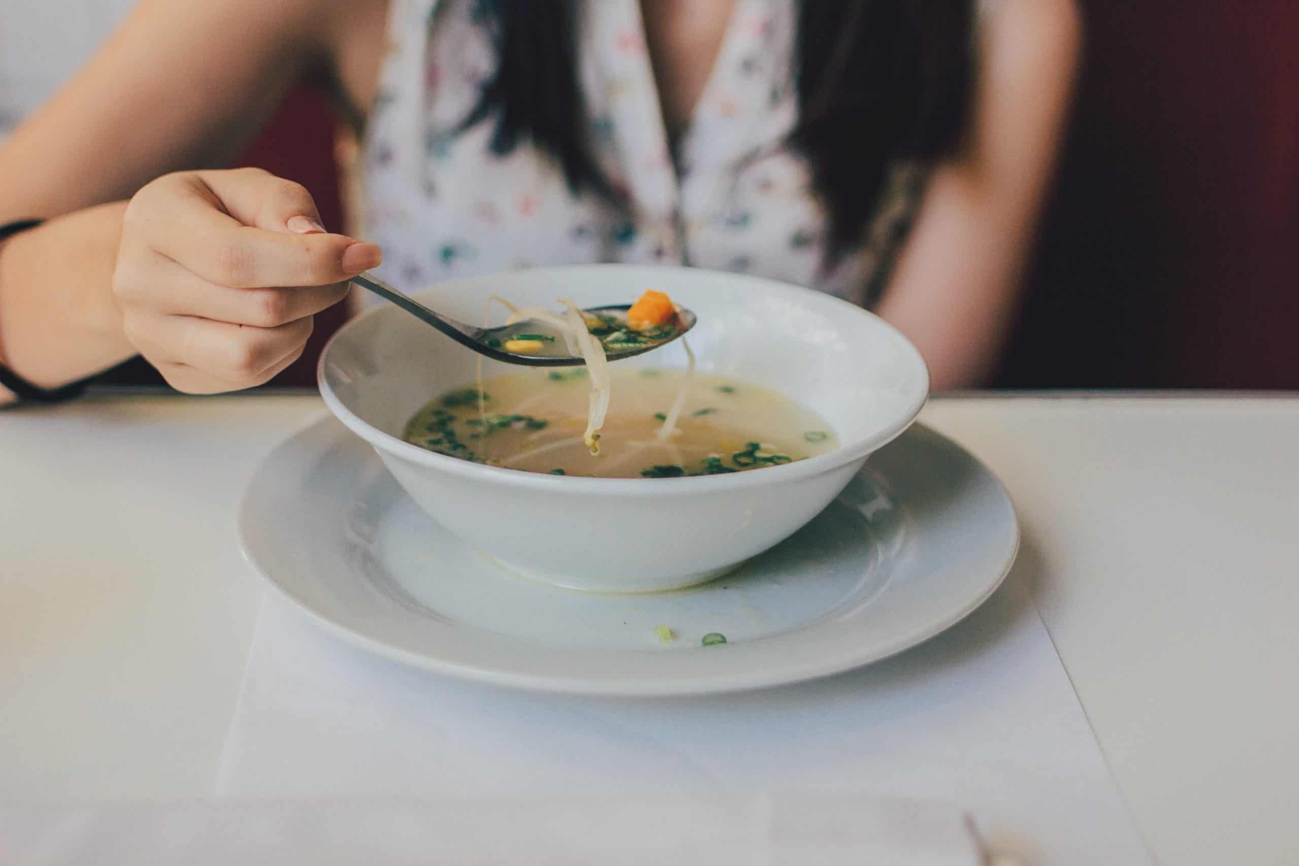 un plato de sopa de verduras con brotes de soja