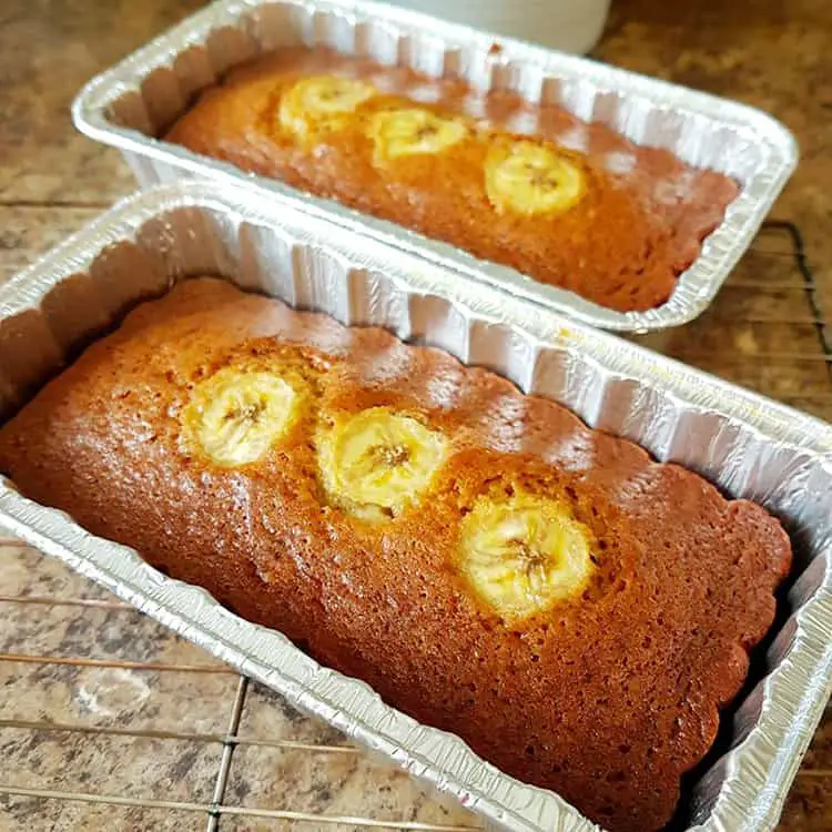 Bananenbrood in een blik met plakjes banaan erop