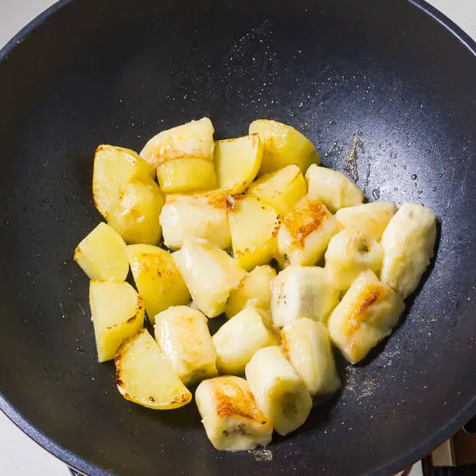 Fried banana and potatoes in a wok