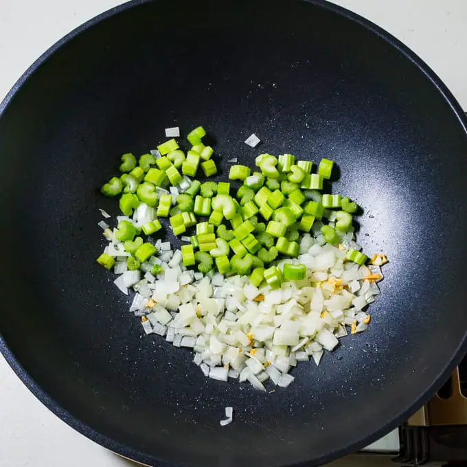 Pancit Bihon garlic onions and celery in a wok