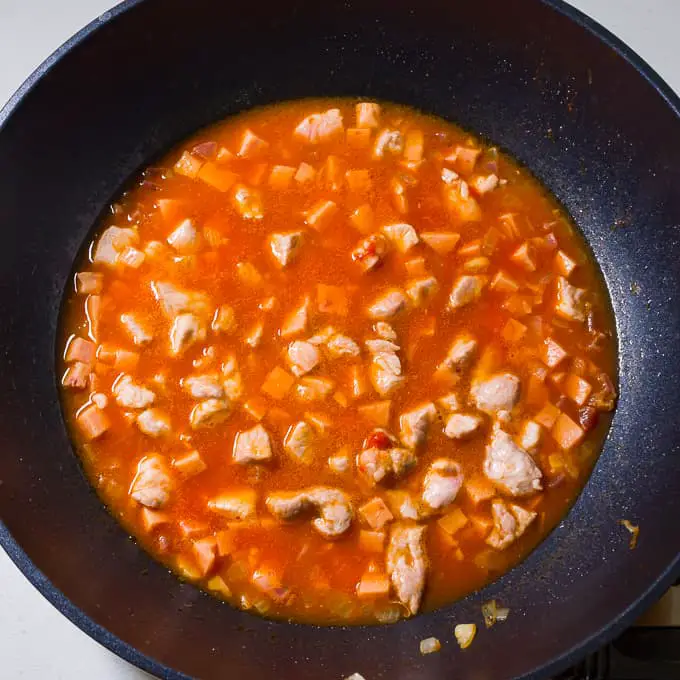 Pork vegetables and tomato sauce in a wok