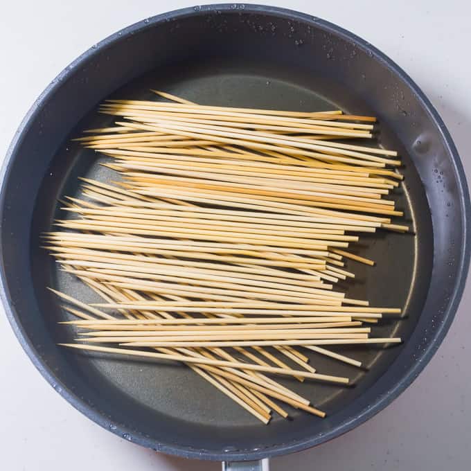 Soaking bamboo barbecue skewers in water