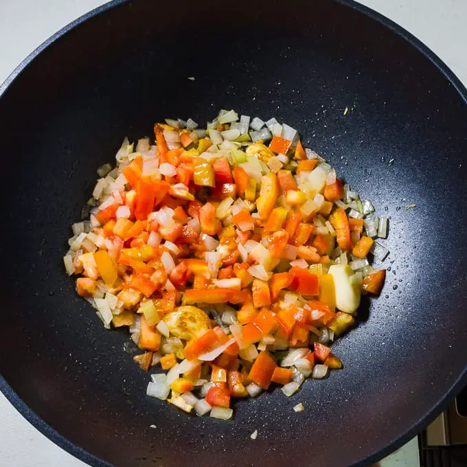 Tomate, cebola e alho em uma wok