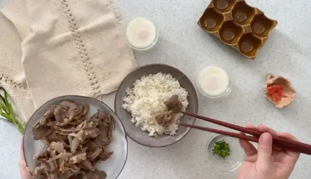 Gyudon adicionando a carne à tigela de arroz para servir