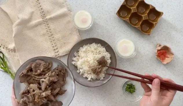 Gyudon pievienojot liellopu gaļu rīsu bļodā pasniegšanai