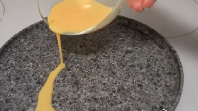 鍋が非常に熱くなったら、卵の混合物を注ぎ、鍋を傾けて完全に卵で覆われるようにします。