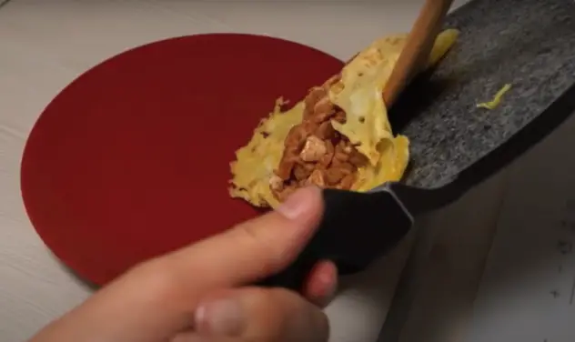 Flip the omurice onto a plate and garnish with more ketchup