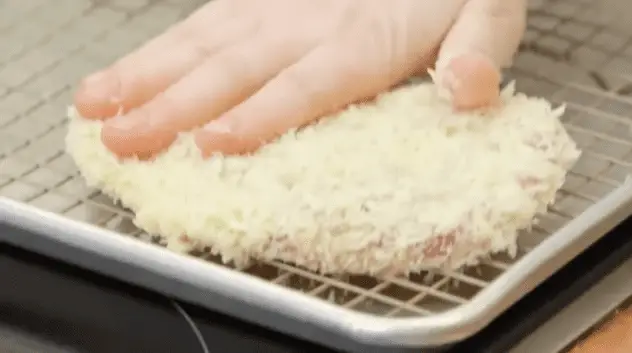 Lägg kotletten i panko, se till att täcka båda sidor väl. Tryck ut köttet i brödsmulorna för att täcka