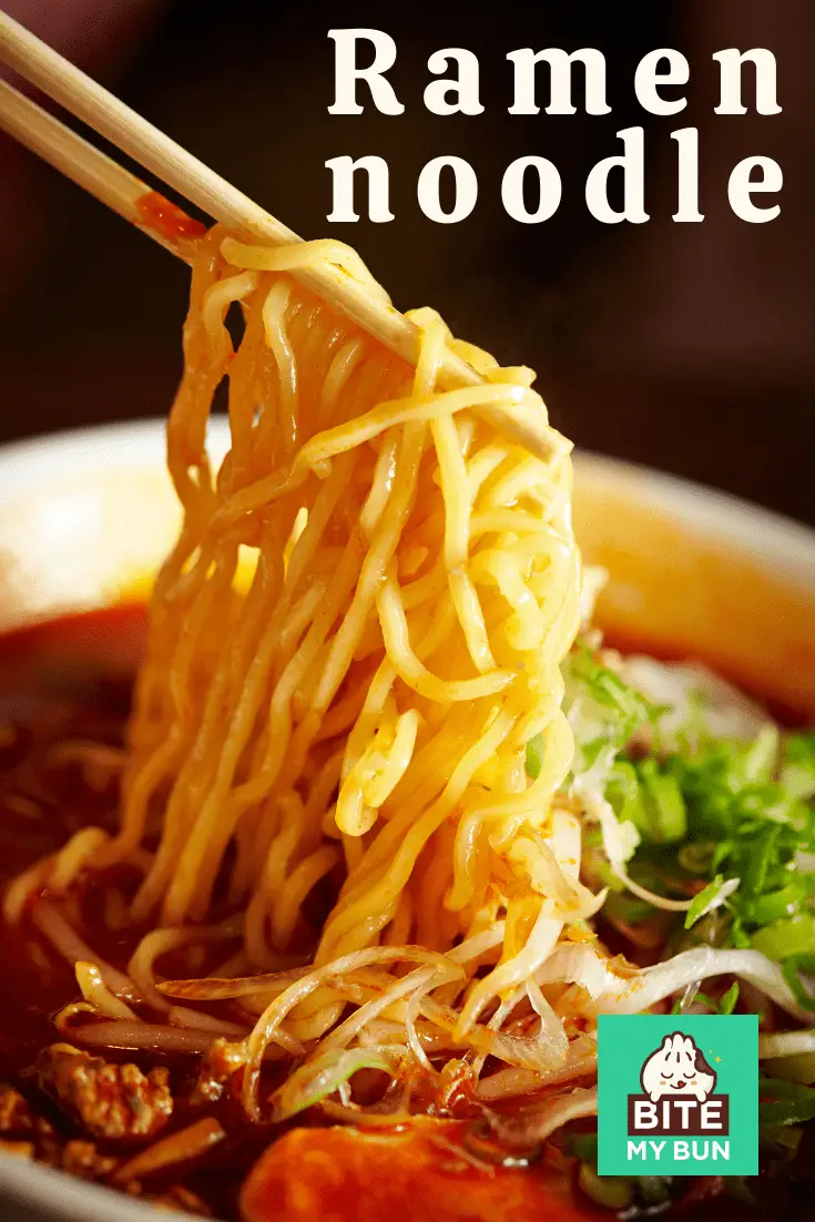 ramen noodles held up with chopsticks against bowl