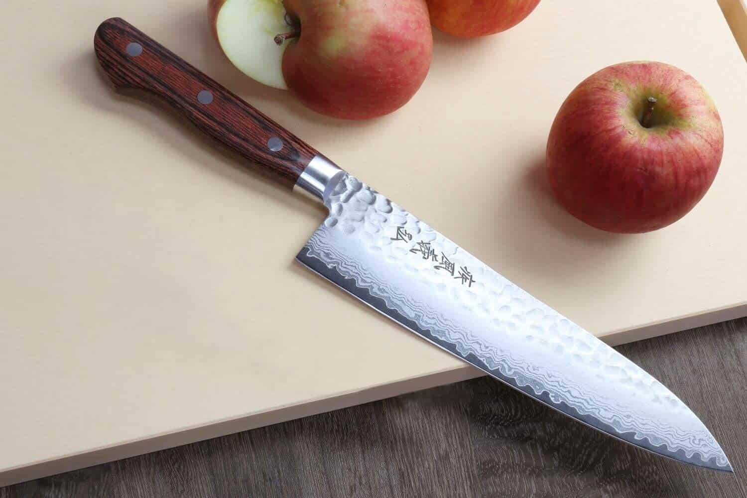 El mejor cuchillo gyuto en general: Yoshihiro VG10 16 Layer Hammered Damascus Gyuto en la mesa