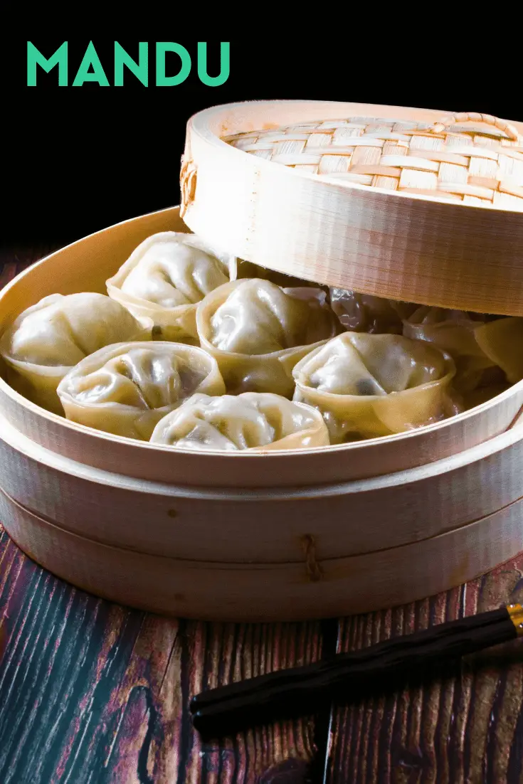 6 mandu dumplings in an open bamboo steamer