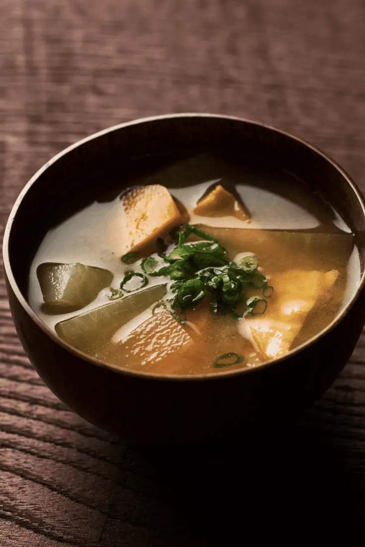tazón de sopa de miso saikyo con daiko y cebollas verdes