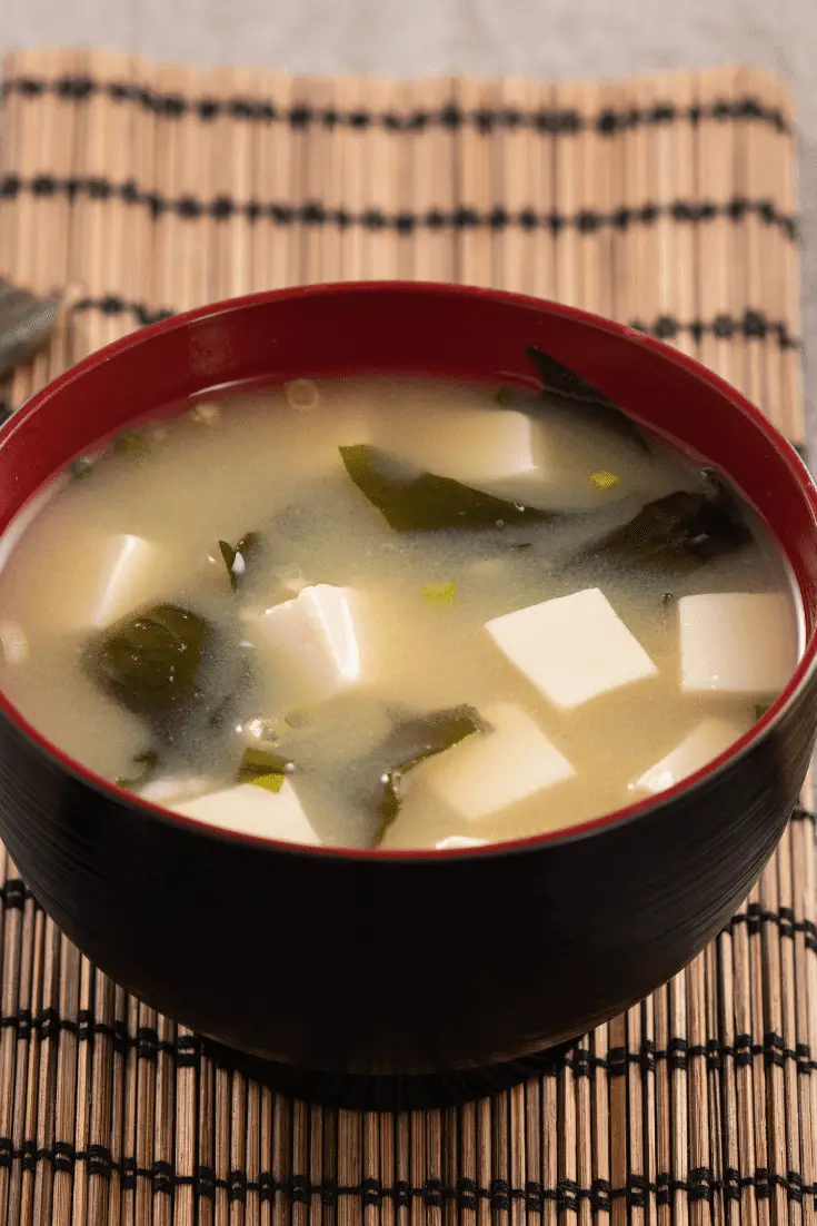 bowl of white miso soup with tofu and seaweed