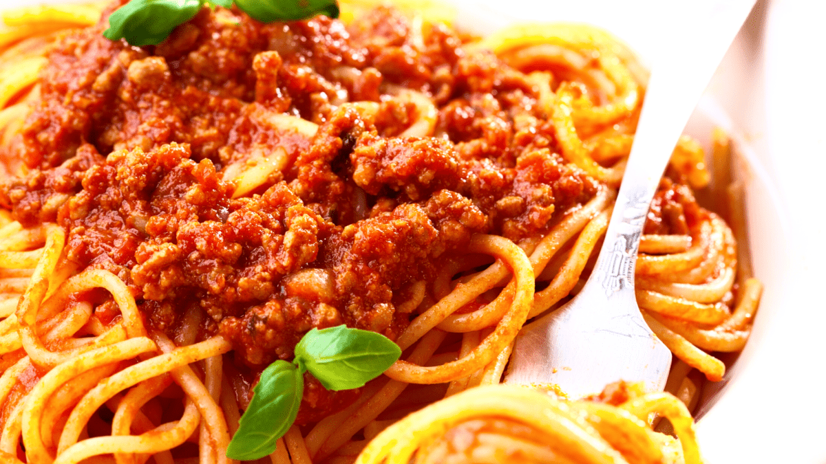 close-up de um prato de espaguete filipino com manjericão por cima