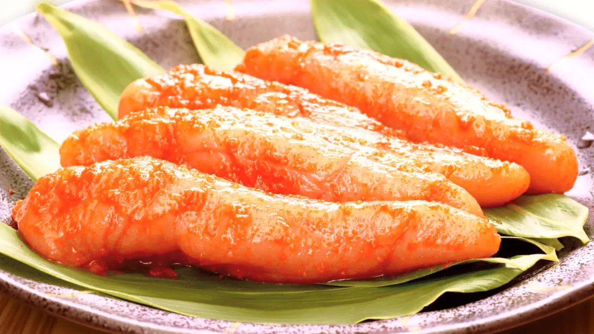 closeup of 4 pieces of mentaiko on leaves