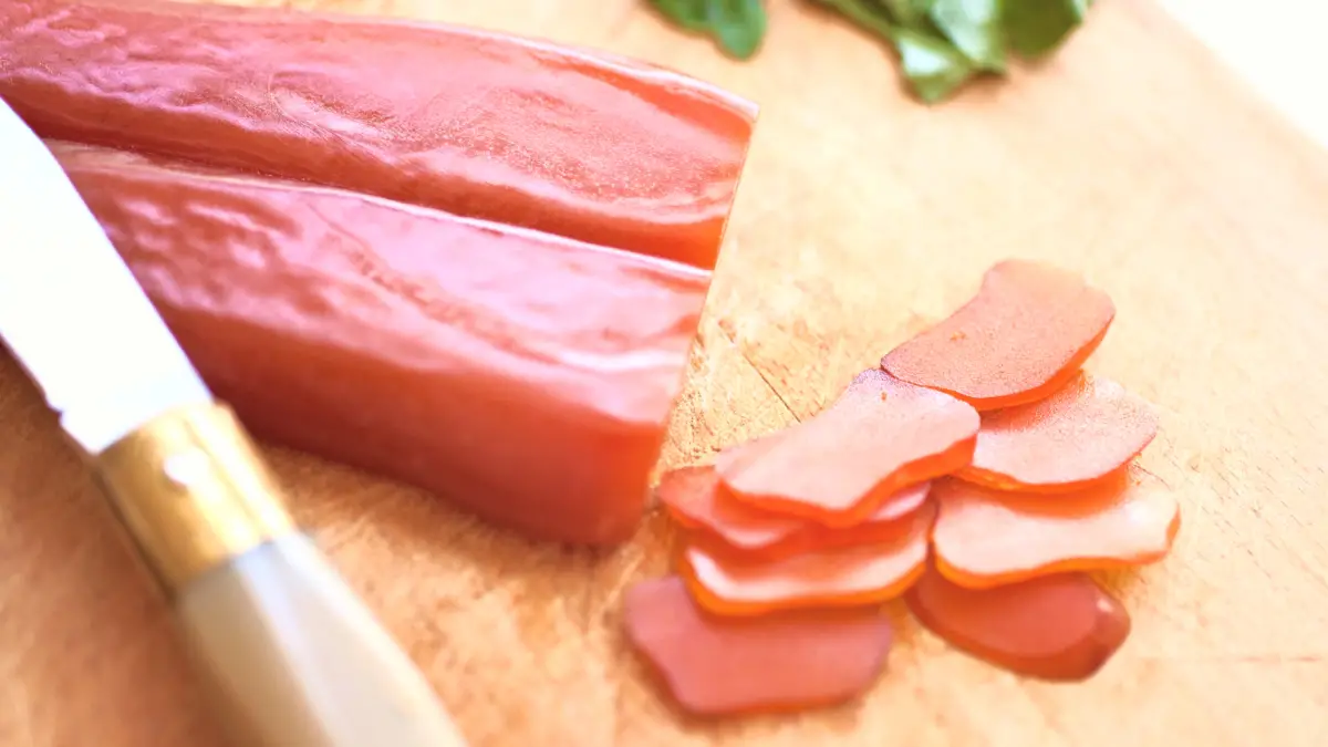 block of tuna bottarga with knife and slices of the bottarga