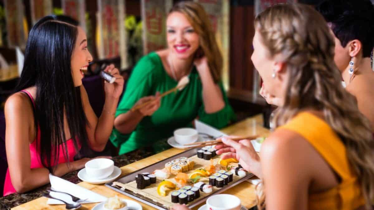 レストランで寿司を食べる 4 人の女性