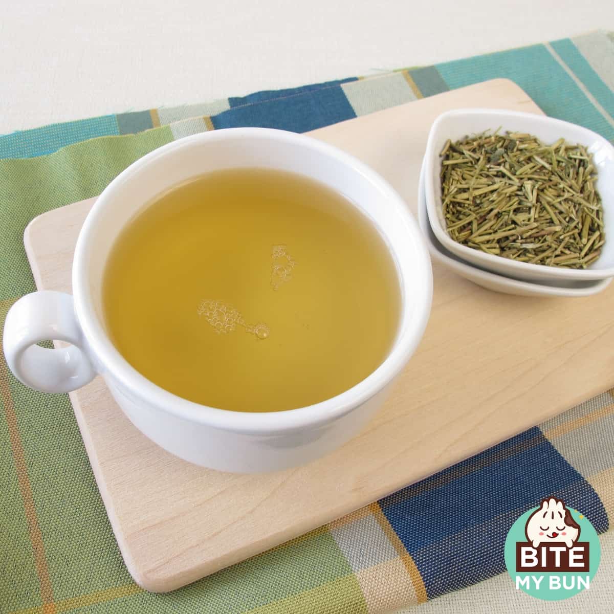 Taza de té Kukicha y hojas sobre la mesa